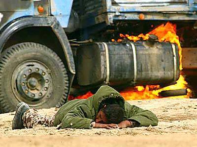 With his truck burning behind him, an Iraqi solider surrenders during a battle with U.S. troops near Nasiriya, Iraq.