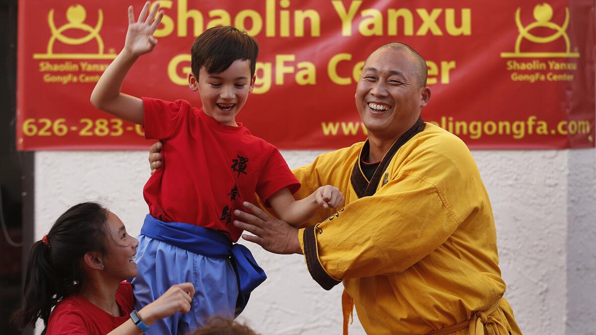 Max Moreno, 7, gets a hand up from Master Shi Yanxu. The master's mission involves establishing more learning centers like the one in Chinatown and raising funds for a temple he hopes to one day build. He teaches 300 students at three centers in Southern California.