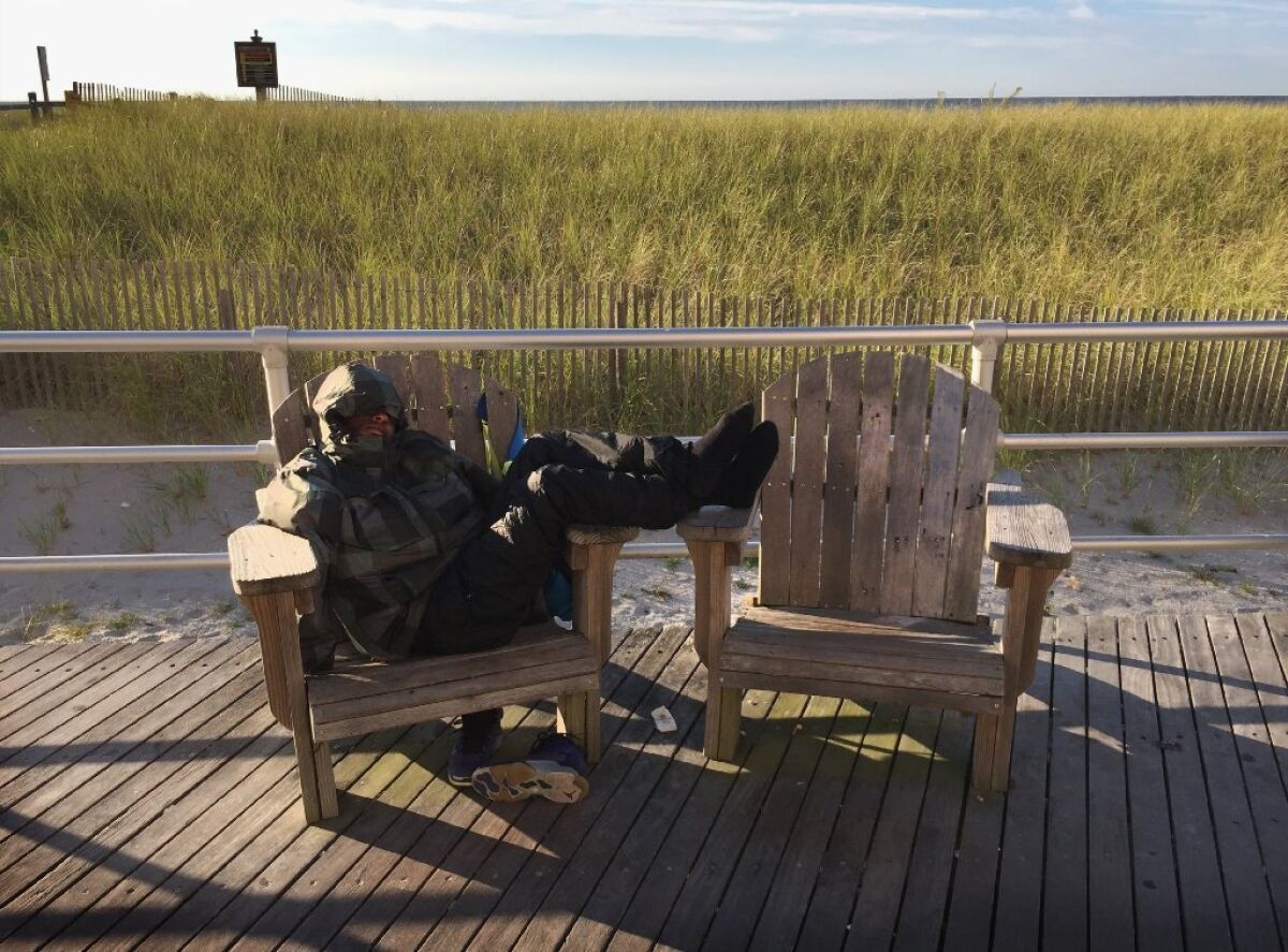 A man sleeps on a Boardwalk bench in Atlantic City, N.J.