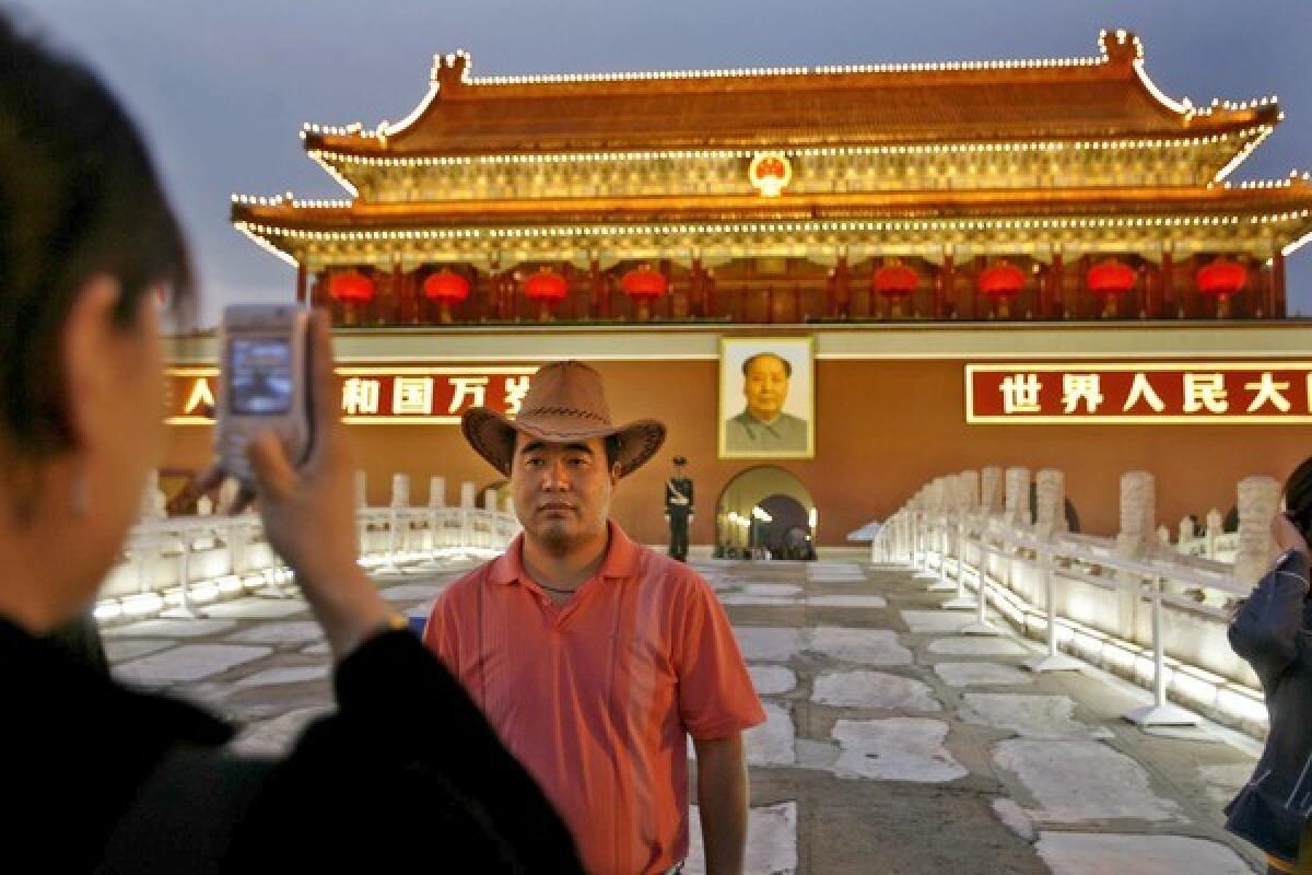 A visitor snaps a photograph at the Forbidden City in Beijing. Alumni travel tours have been in existence since the 1970s.