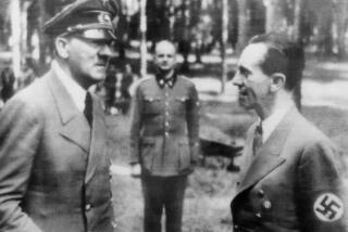 In this official Nazi photo obtained by The Associated Press via neutral Swedish photo agency Pressens Bild, German caption describes a meeting of Adolf Hitler with Dr. Joseph Goebbels, right, at Der Fuhrer's headquarters after a recent assassination attempt, July 27, 1944. Man at center is unidentified. (Nazi Government/Buro Laux/Pressens Bild via AP)