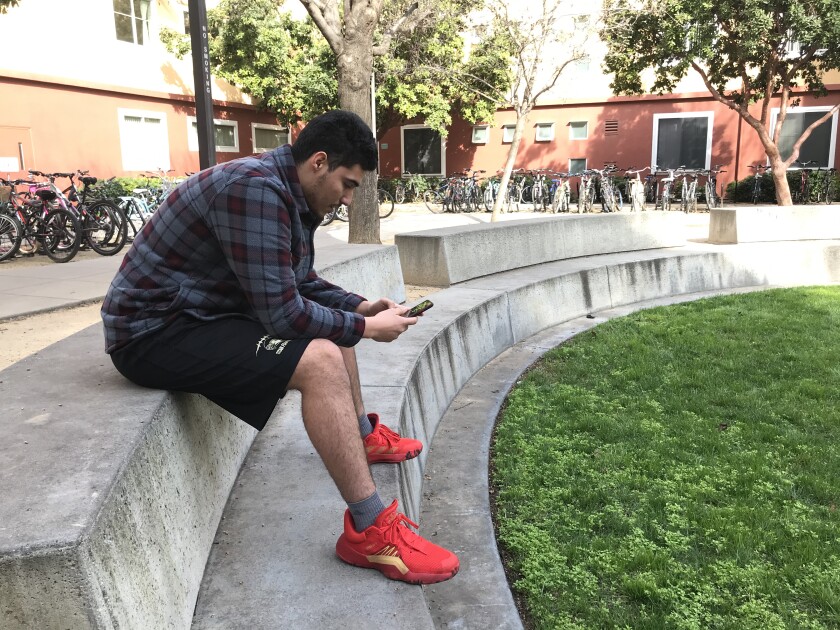 A man sits on a concrete bench.