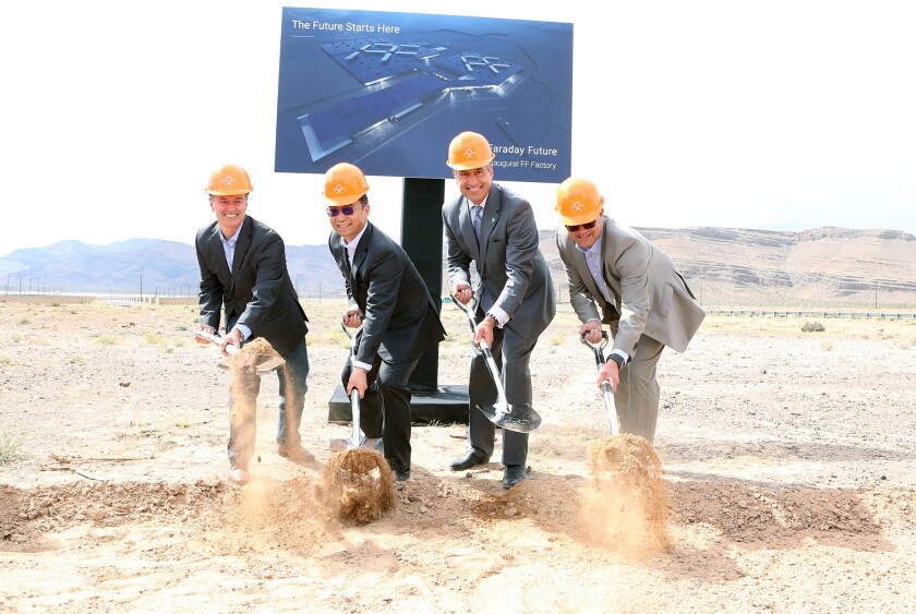 Faraday Future executives and Nevada Gov. Brian Sandoval dig into the dirt in North Las Vegas at a groundbreaking ceremony Wednesday. The state granted the automaker tax breaks to develop a factory there.