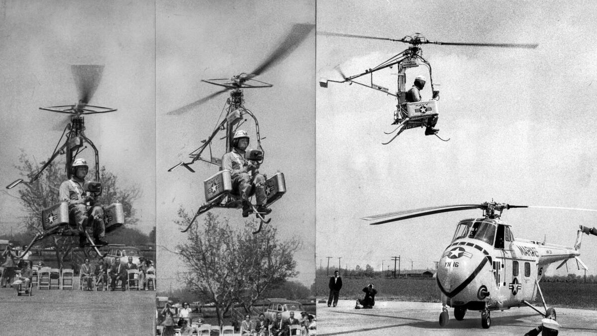 April 15, 1957: The Pinwheel, a rocket-powered, strap-on-the-back helicopter, rises and hovers over a larger craft during its first demonstration.