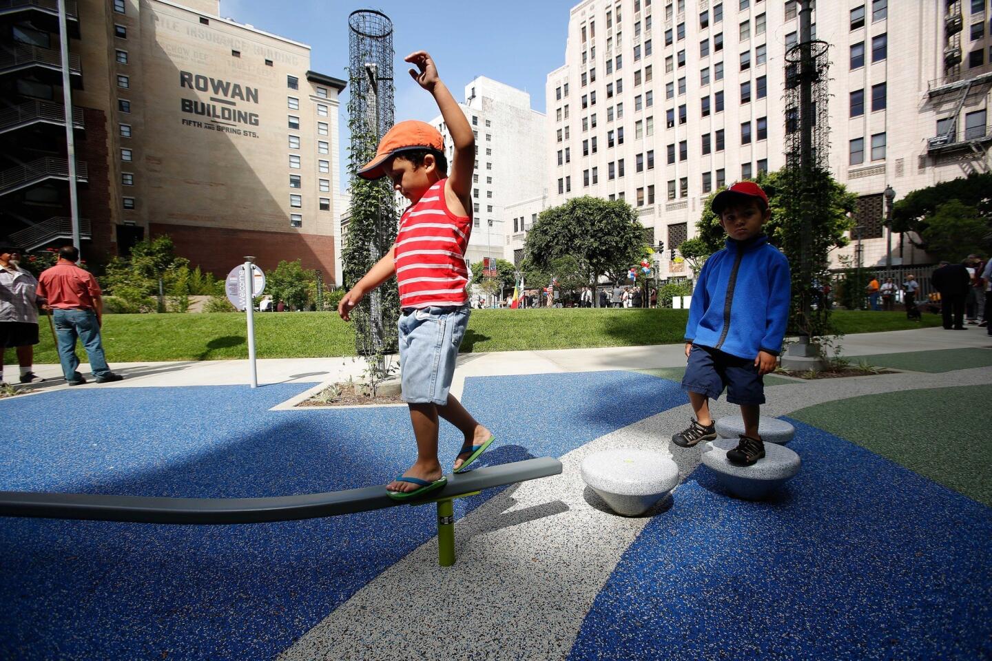 Matteo Walters, 4, left, keeps his balance while playing in the park with his brother Angelo, 3, right. The park, which is roughly 2/3 of an acre, sits atop a former parking lot between 4th and 5th streets.