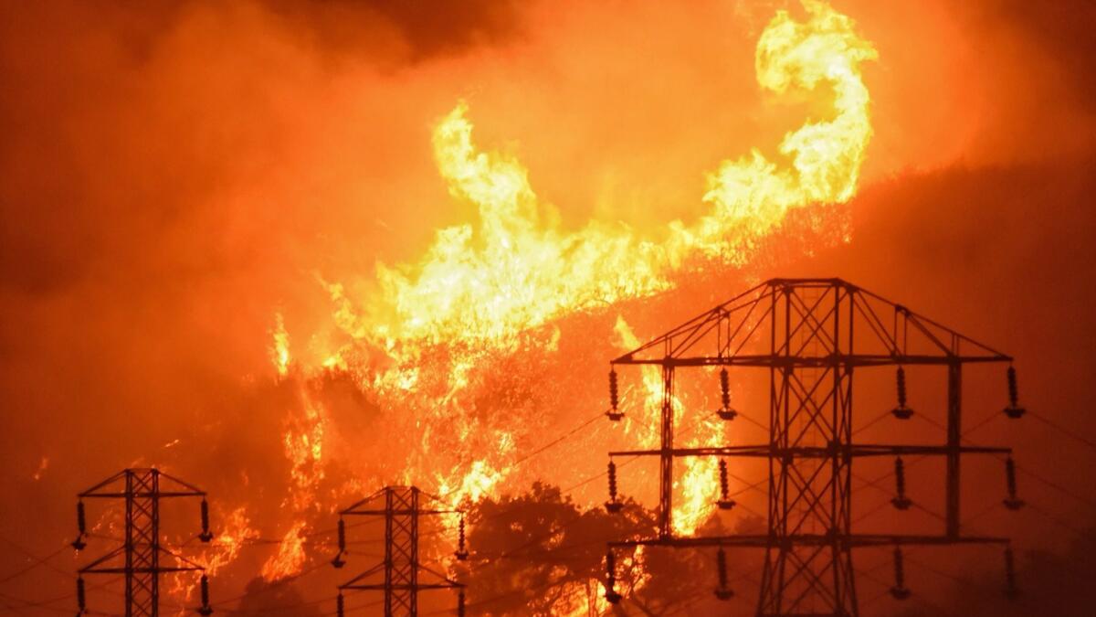 Flames burn near power lines in Montecito, Calif. on Dec. 16, 2017.