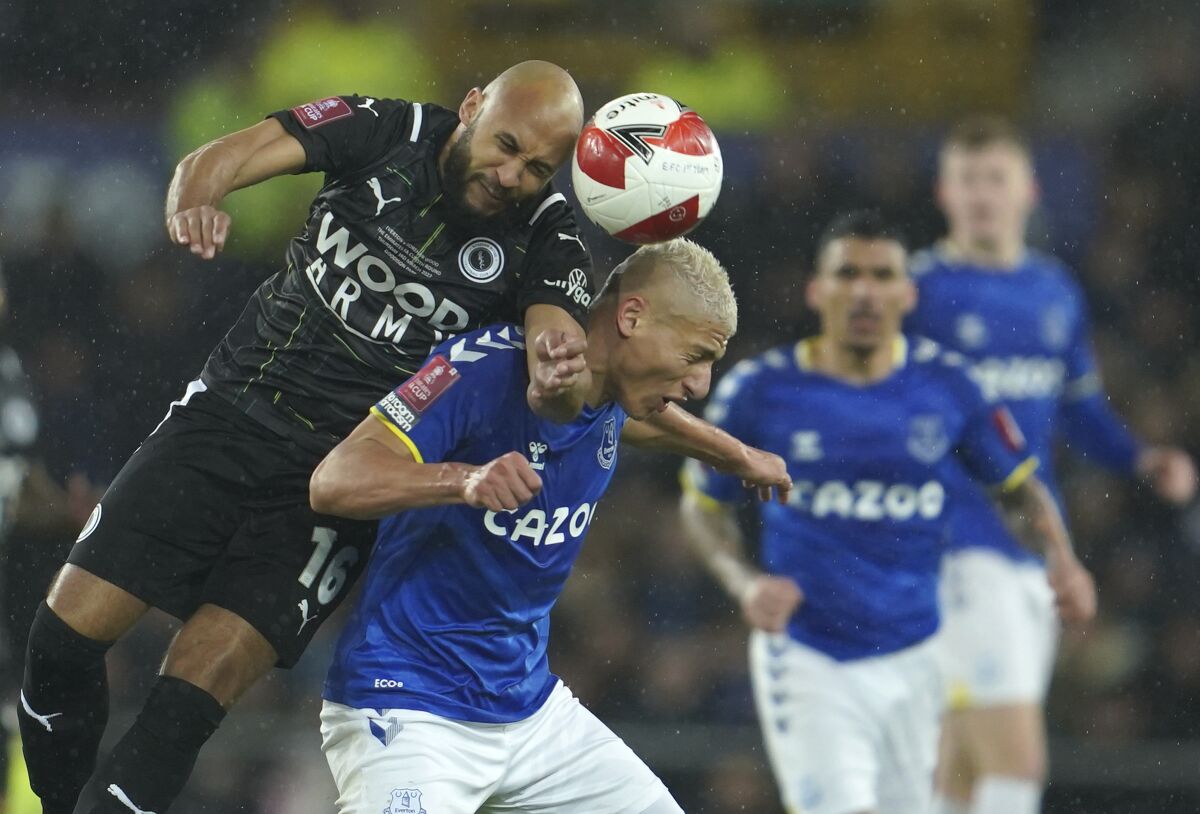 Boreham Wood's James Comley, top, challenges Everton's Richarlison during the English FA Cup 5th round soccer match between Everton and Boreham Wood at Goodison Park in Liverpool, England, Thursday, March 3, 2022. (AP Photo/Jon Super)