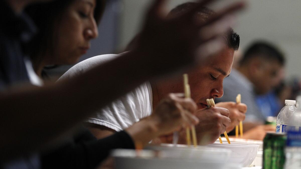 Tony Garcia, center, an officer with the Los Angeles Police Department's Olympic Division, uses chopsticks to eat bibimbap during a Korean cultural workshop for law enforcement.