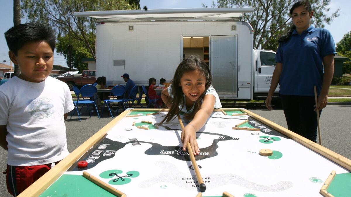 Children play pocket golf during a visit by the Costa Mesa mobile recreation program in 2009, shortly before it was ended because of budget cuts. It is returning this year.