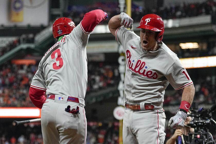 Philadelphia Phillies' J.T. Realmuto, right, celebrates his solo homer with Philadelphia Phillies Bryce Harper.