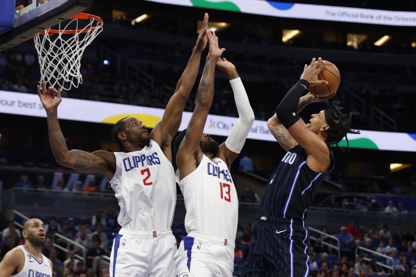 Orlando Magic forward Paolo Banchero shoots over Los Angeles Clippers forward Kawhi Leonard (2) and guard Paul George (13) during the first half of an NBA basketball game Wednesday, Dec. 7, 2022, in Orlando, Fla. (AP Photo/Scott Audette)