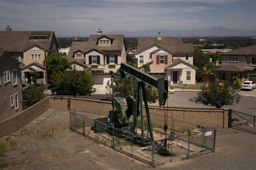 FILE— A pump jack extracts oil at a drilling site next to homes Wednesday, June 9, 2021, in Signal Hill, Calif. California legislators passed a bill, on Wednesday, Aug. 31, 2022, to ban new oil and gas wells within 3,200 feet of homes, schools and other neighborhood sites. It now goes to Gov. Gavin Newsom, who is expected to sign it. (AP Photo/Jae C. Hong, File)
