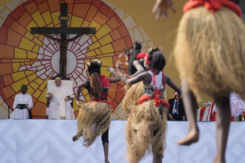 Pope Francis, second from left, looks at traditional dancers performing at the Martyrs' Stadium In Kinshasa, Democratic Republic of Congo, Thursday, Feb. 2, 2023. Francis is in Congo and South Sudan for a six-day trip, hoping to bring comfort and encouragement to two countries that have been riven by poverty, conflicts and what he calls a "colonialist mentality" that has exploited Africa for centuries. (AP Photo/Gregorio Borgia)