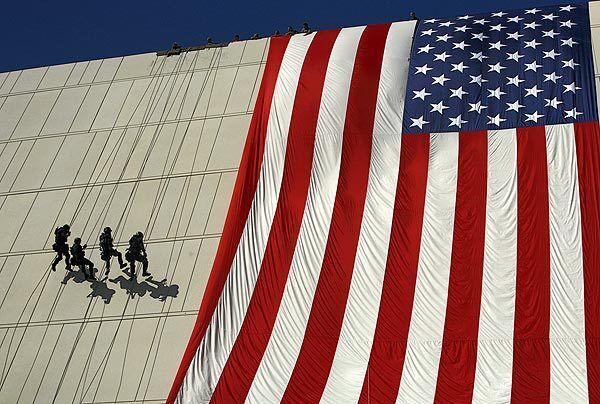 The Los Angeles Police Department SWAT Team rappels down the new building next to a freshly unfurled flag during the grand opening ceremony.