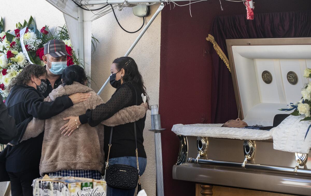 Family and friends console one another as they gather at a service for Julio Aguilar on Dec. 20 in East Los Angeles. 