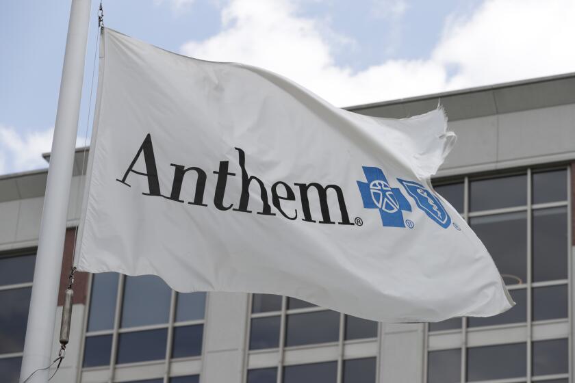 FILE - In this May 14, 2019, file photo a flag flies the outside of the corporate headquarters building of health insurance company Anthem is shown in Indianapolis. Anthem and Wall Street are starting 2021 with different ideas for how the health insurer’s year will turn out. The Blue Cross-Blue Shield insurer said Wednesday that it expects adjusted annual earnings to be greater than $24.50 per share, counting hits it expects from the COVID-19 pandemic and a recently passed Congressional spending bill. (AP Photo/Michael Conroy, File)
