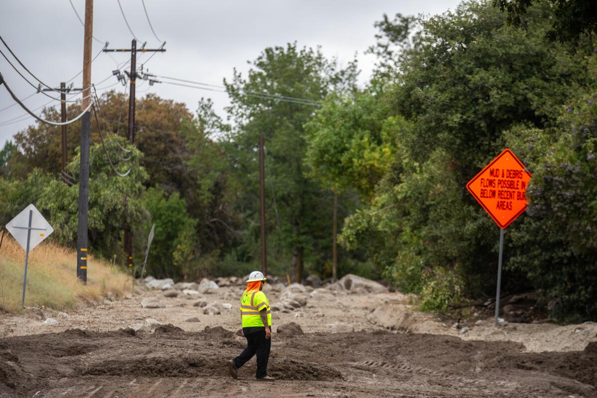 Michael Nakama, 42, with San Bernardino County, evaluates the mud on Potato Canyon Road in Oak Glen.