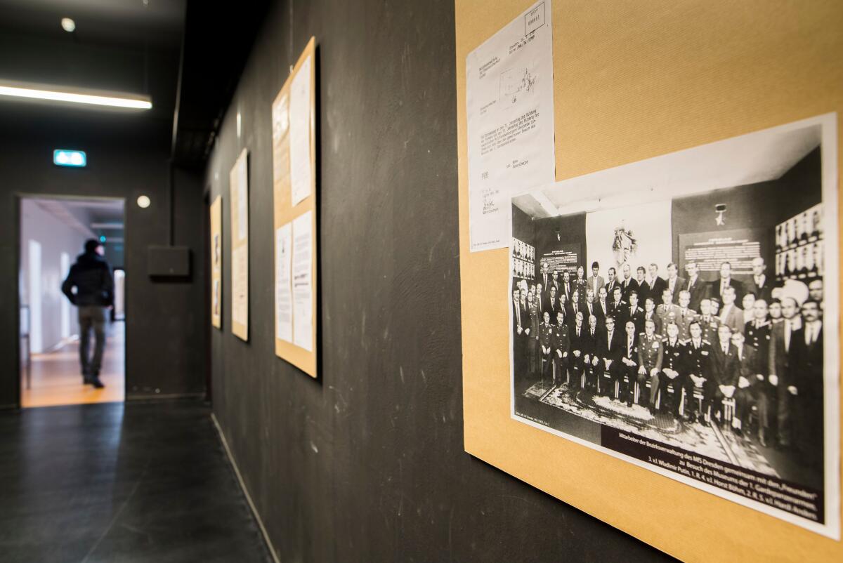 A large black and white photo hanging in a hallway of a group of people  