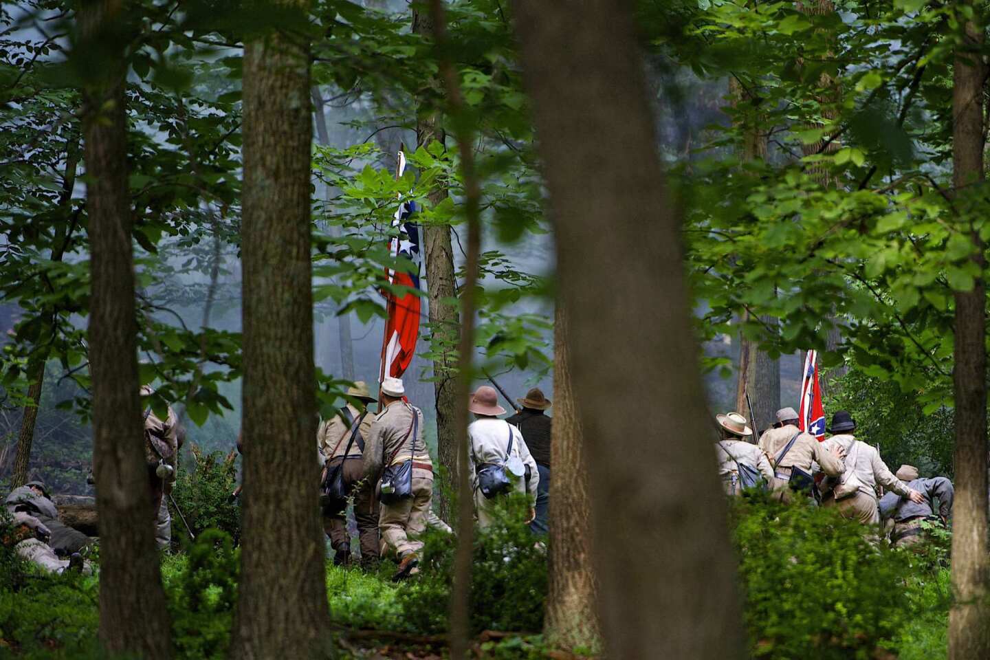 Actors playing Confederate troops charge up a hill during reenactment marking the 150th anniversary of the Battle of Gettysburg, in Gettysburg
