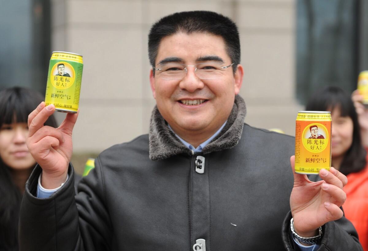 Chen Guangbiao hands out cans of fresh air in a financial district in Beijing.