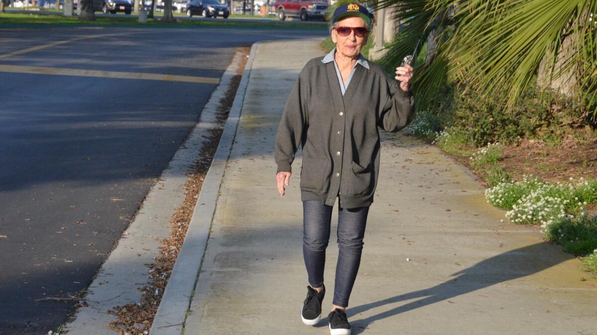 Kathleen Brennan, 91, of Newport Beach takes a brisk walk every day while carrying her transistor radio.