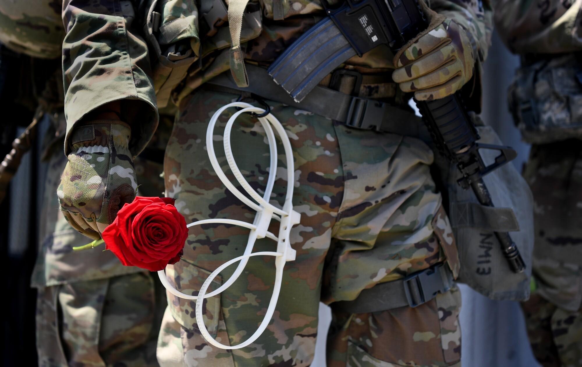 A National Guardsman holds a rose given to him by a protester along Fairfax Avenue during a march.