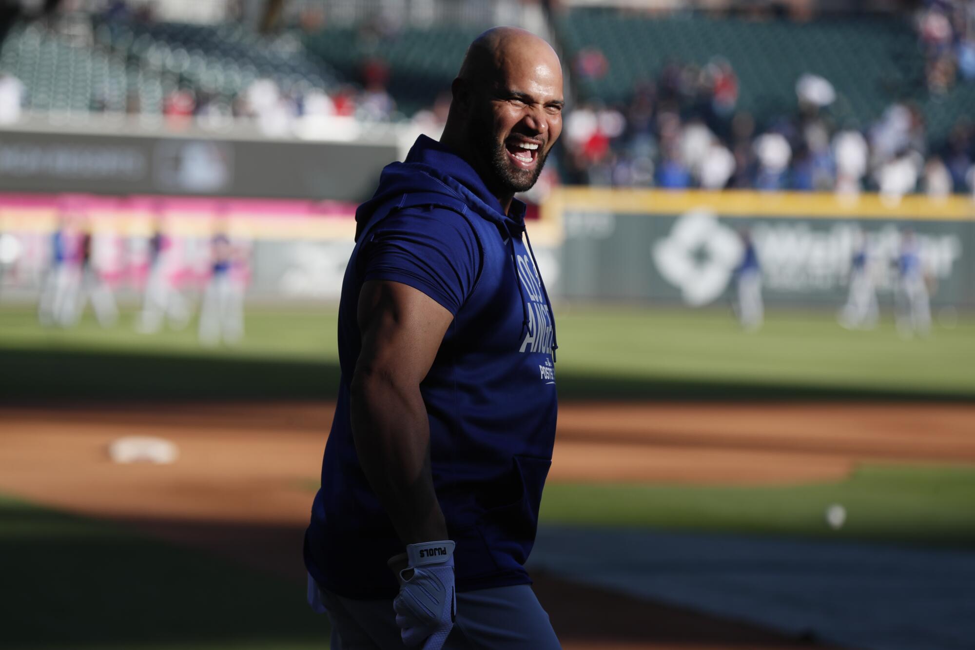 Los Angeles Dodgers' Albert Pujols keeps it light during batting practice before Game 2.