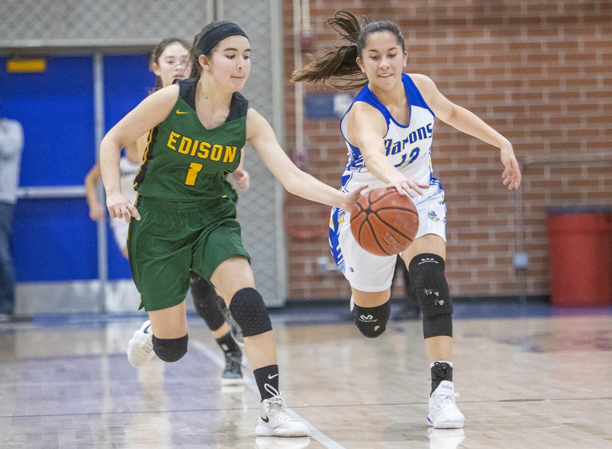 Edison's Noelle Duffey, left, and Fountain Valley's Margaret Tengan battle for a loose ball in a Sunset Conference crossover game on Thursday.