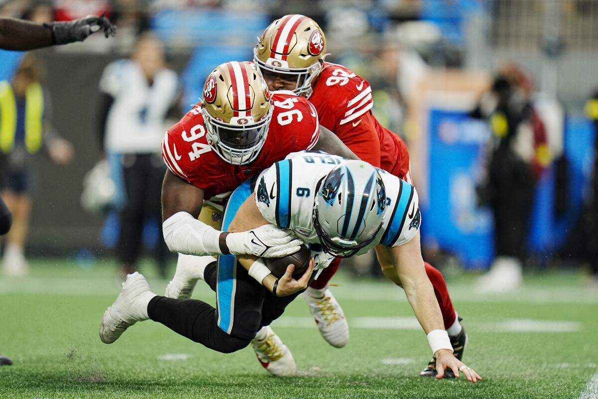 Carolina Panthers quarterback Baker Mayfield is sacked by San Francisco 49ers defensive end Charles Omenihu and defensive end Kerry Hyder Jr. during the second half an NFL football game on Sunday, Oct. 9, 2022, in Charlotte, N.C. (AP Photo/Rusty Jones)