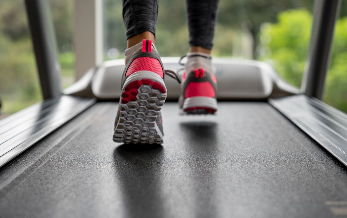 A woman's feet move on a treadmill belt.