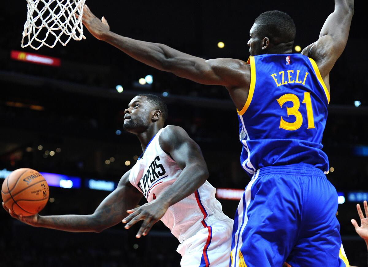 Clippers guard Lance Stephenson beats Warriors Festus Ezeli to the hoop for a basket during a preseaosn game on Oct. 20 at Staples Center.