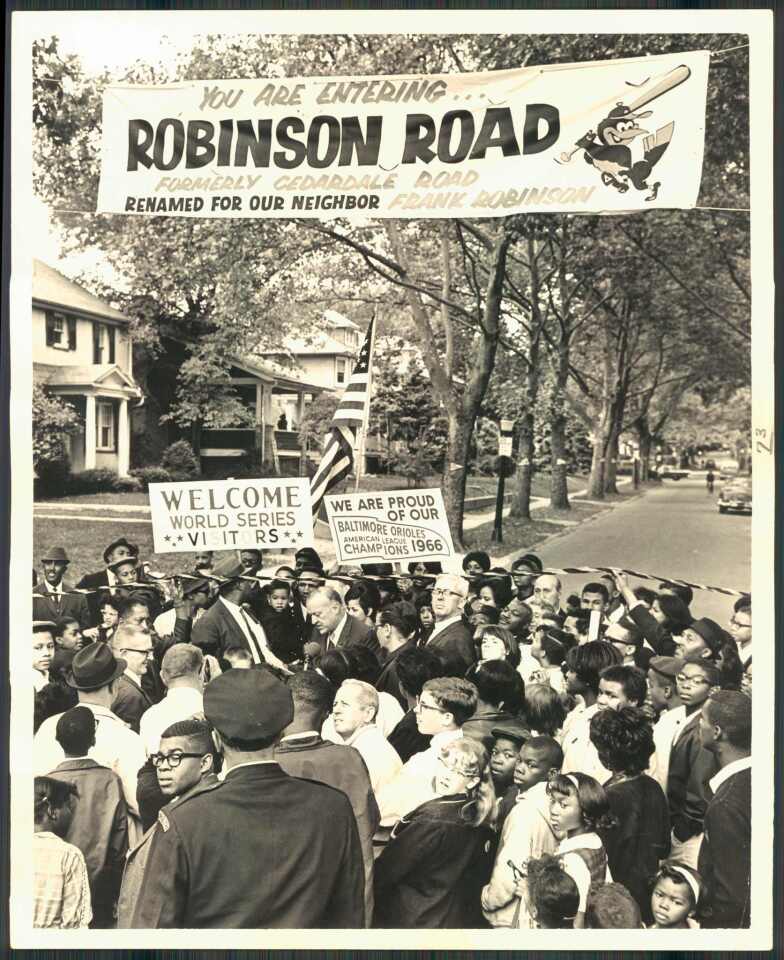 Amid a swarm of children and parents, Mayor Theodore McKeldin announces a tempoary name change for Cedardale Road to Robinson Road for Orioles slugger Frank Robinson , Orioles Slugger, standing behind him along with his son and wife on Sept. 27, 1966.