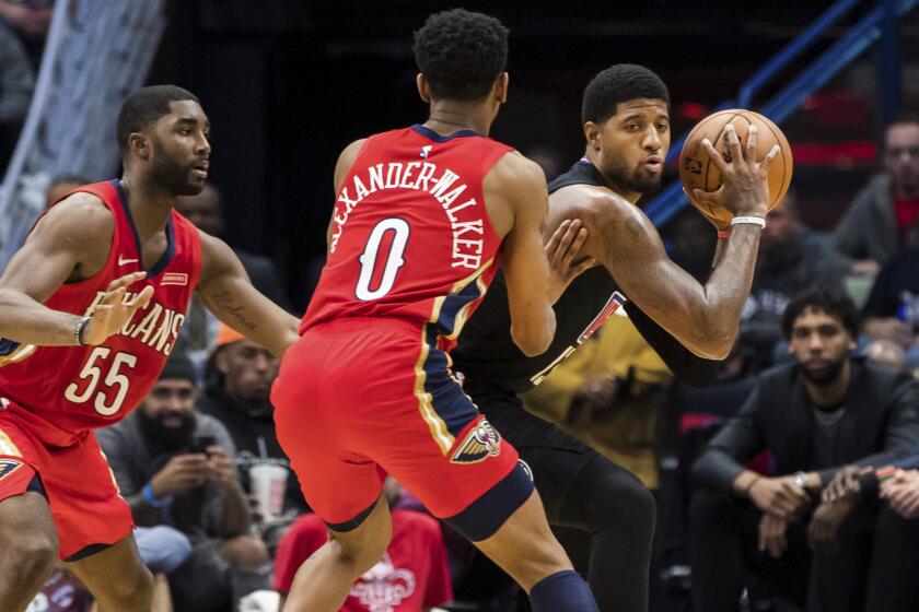 Clippers forward Paul George is trapped by the double-team defense of New Orleans' E'Twaun Moore, left, and Nickeil Alexander-Walker during their game Nov. 14, 2019.