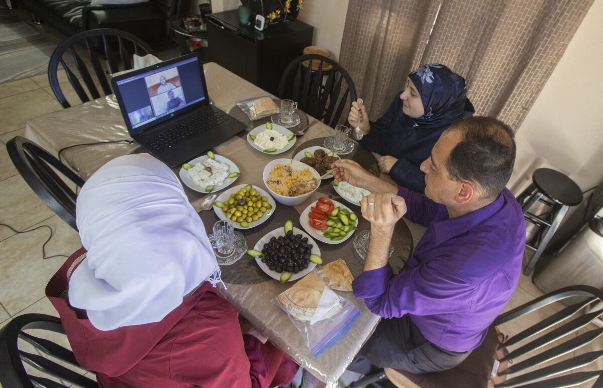 The Alsidnawi family eats a meal.