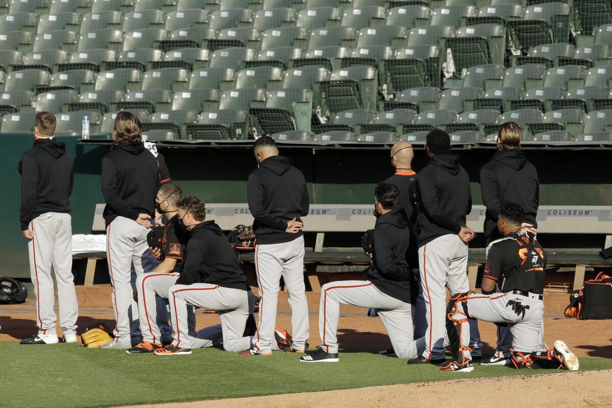 Some members of the San Francisco Giants kneel during the national anthem July 20 in Oakland.