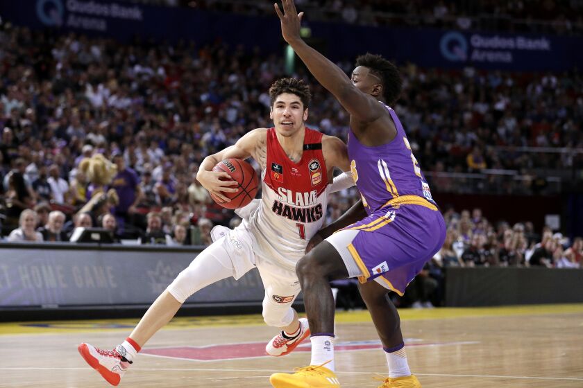 LaMelo Ball of the Illawarra Hawks drives past Jae'Sean Tate of the Sydney Kings during their game in the Australian Basketball League in Sydney, Sunday, Nov. 17, 2019. (AP Photo/Rick Rycroft)