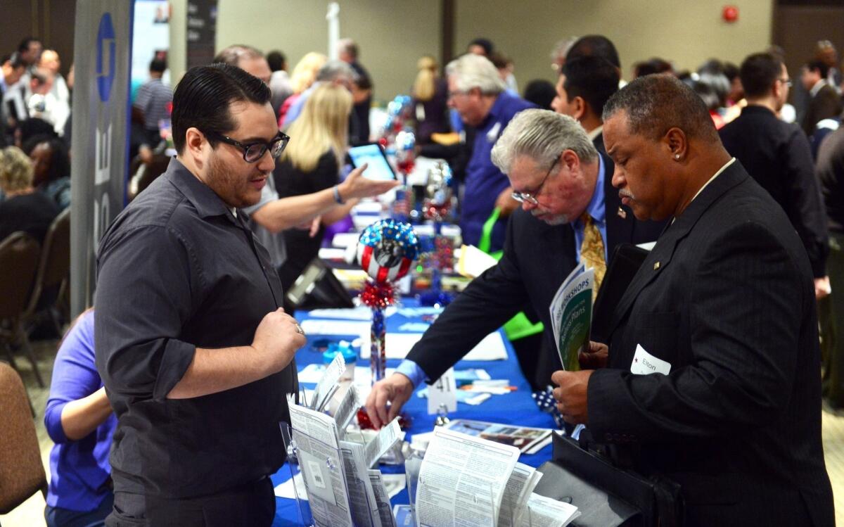 California added 44,300 jobs in November, helping push the unemployment rate down to 8.5% from 8.7% the month before. Above, job seekers meet with company representatives at an employment fair in Van Nuys.