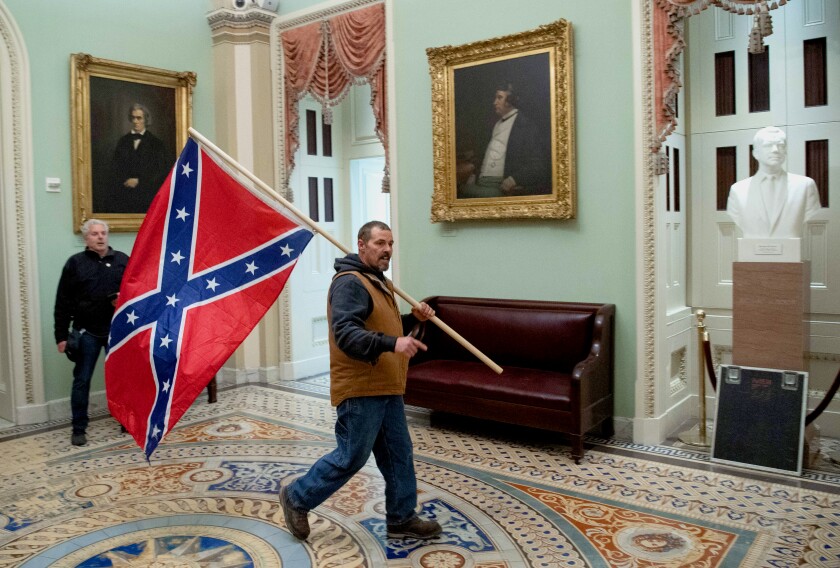 A man carries a Confederate flag through the Capitol rotunda.
