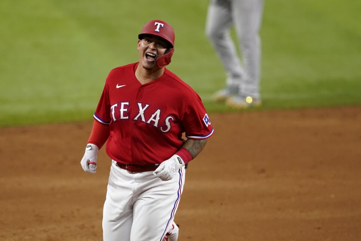 Texas Rangers' Yohel Pozo smiles as he rounds the bases on the way home after hitting a three-run home run in the sixth inning of a baseball game against the Oakland Athletics in Arlington, Texas, Friday, Aug. 13, 2021. The shot, that came off relief pitcher Sergio Romo, also scored Andy Ibanez and Jason Martin. (AP Photo/Tony Gutierrez)