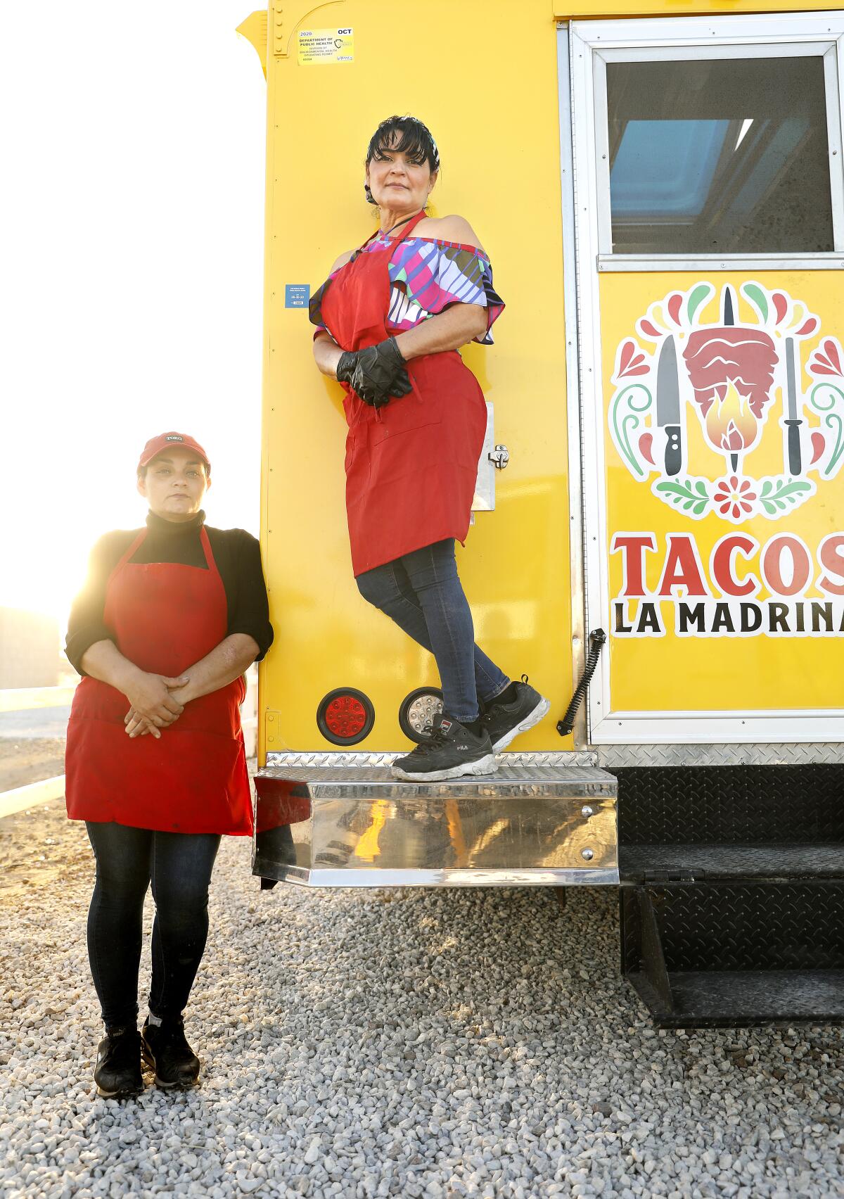 María Cárdenas, a la derecha, y su hermana Esmeralda Cárdenas, a la izquierda, unieron sus ahorros para comprar el camión de comida de Tacos La Madrina, que Cárdenas supervisa en Hesperia.