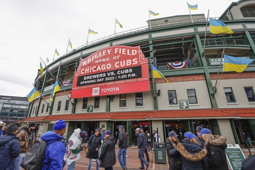 Ukrainian flags are seen outside Wrigley Field as fans arrive for the Chicago Cubs home-opener baseball game against the Milwaukee Brewers, Thursday, April 7, 2022, in Chicago. (AP Photo/Kamil Krzaczynski)