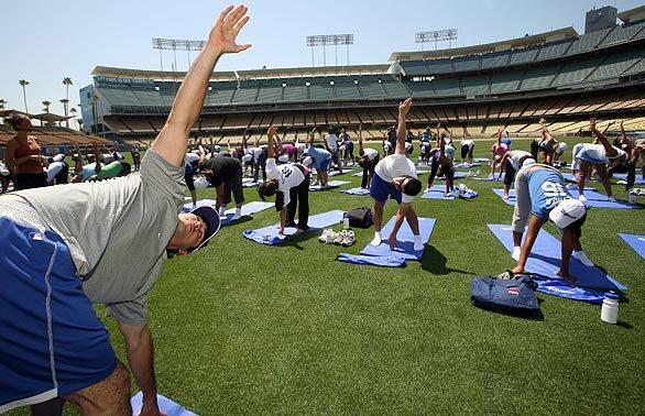 Dodgers outfielder Andre Eithier leads hundred of fans in a yoga session at Dodger Stadium. About 100 fans paid $100 a pop for the privilege.
