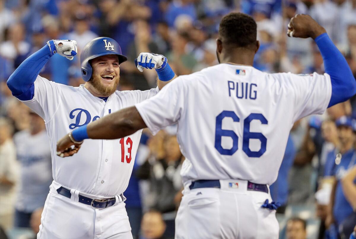 Dodgers Max Muncy celebrates with Yasiel Puig after hitting a three-run homerun in the second inning.