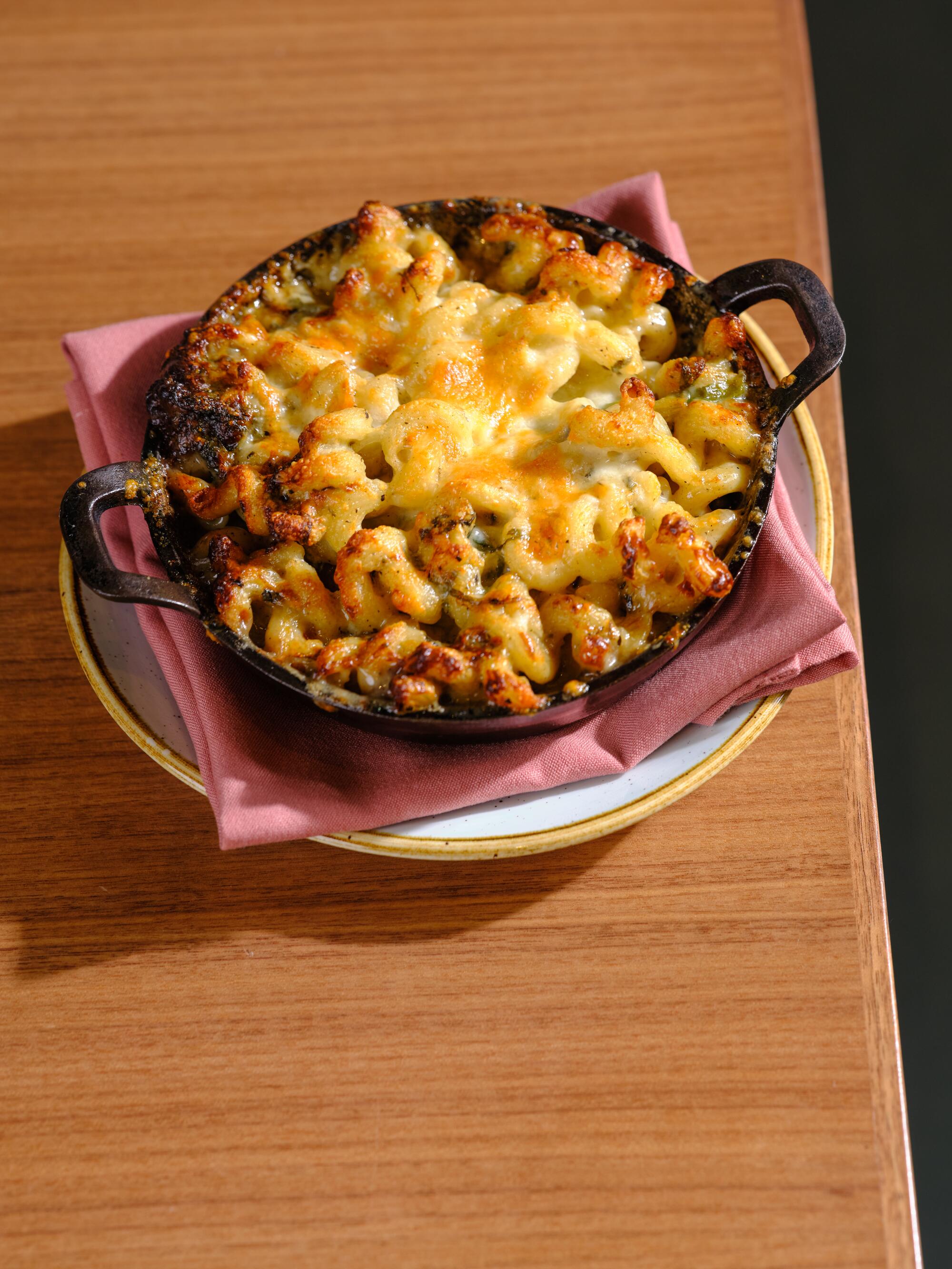 A plate of macaroni and cheese on a wooden table.