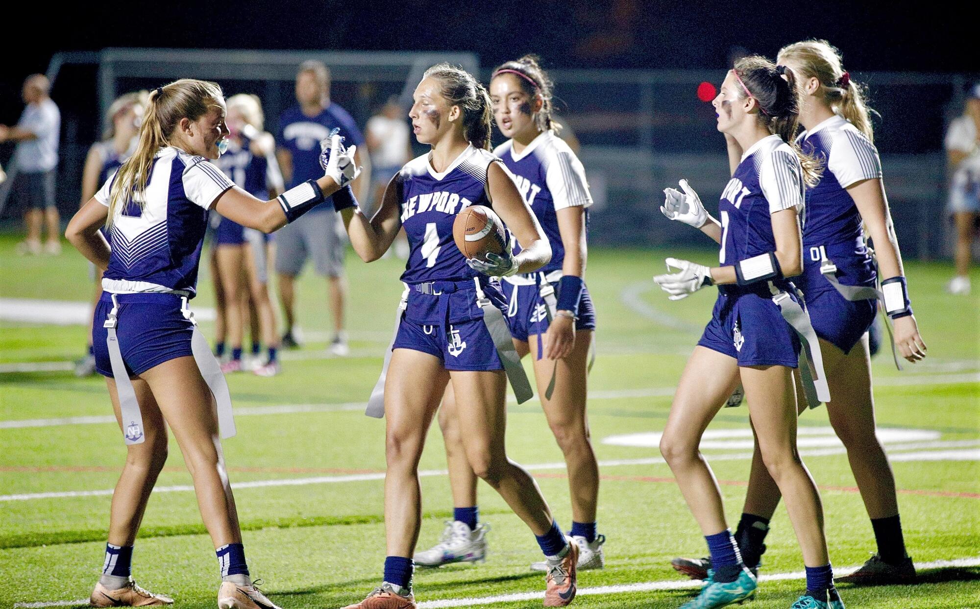 Kate Kubiak is congratulated by Newport Harbor High teammates after scoring a touchdown.