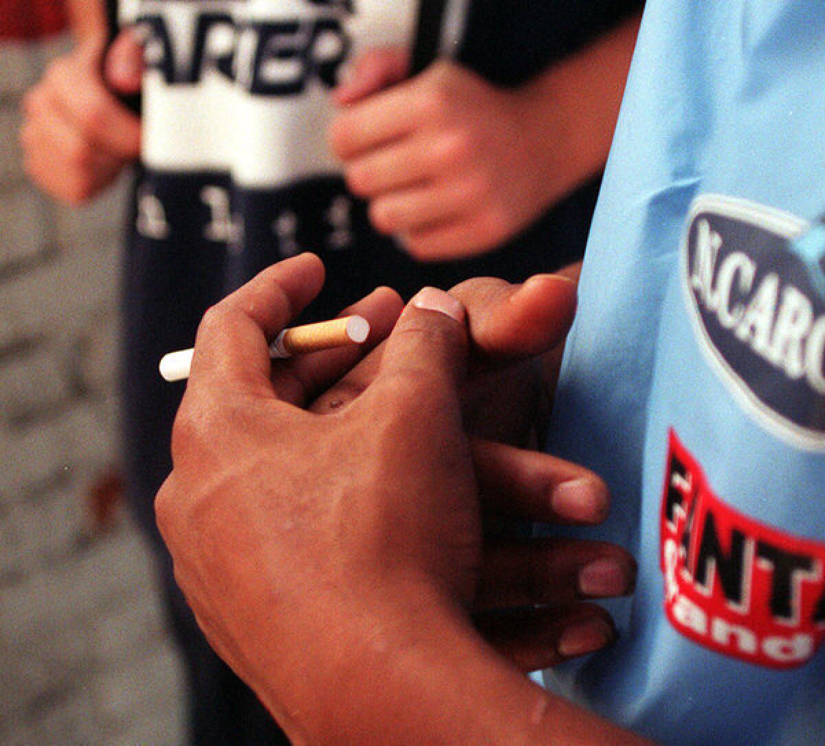 Students smoking outside Santa Monica High School. A tobacco tax could raise money for college aid.