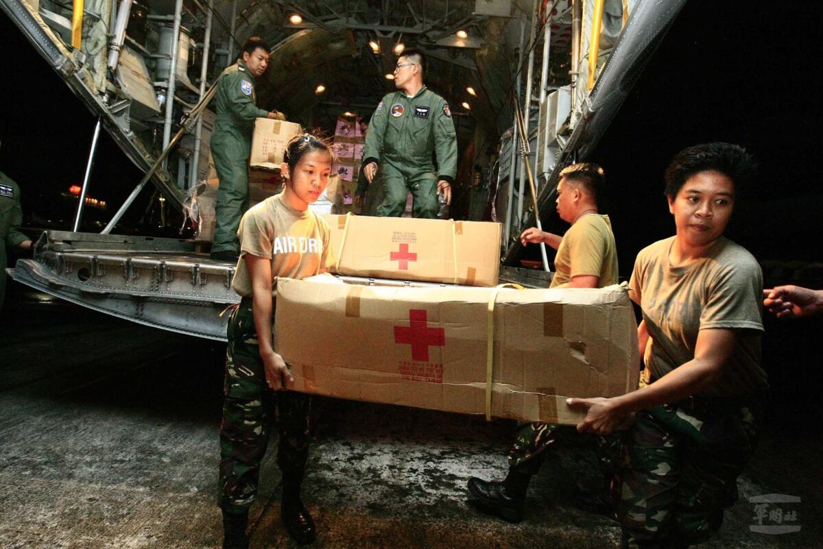 Soldiers and volunteers unload relief goods from a Taiwanese C-130 military cargo plane at Cebu International Airport in the Philippines.