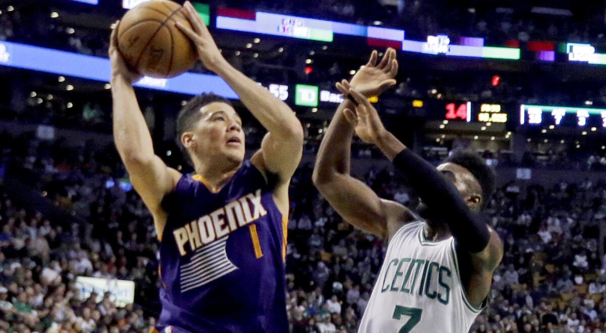 Suns guard Devin Booker drives for a layup against Celtics forward Jaylen Brown during his 70-point game.