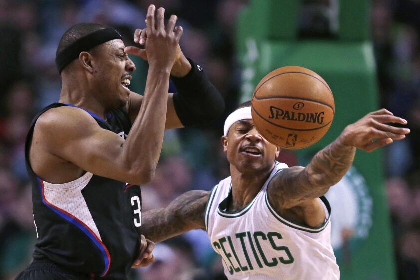 Celtics guard Isaiah Thomas, right, knocks away a pass to Clippers forward Paul Pierce during the first quarter of a game on Feb. 10.