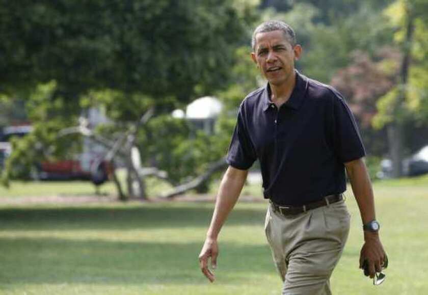 President Obama walks on the South Lawn of the White House after returning from a trip to Camp David.